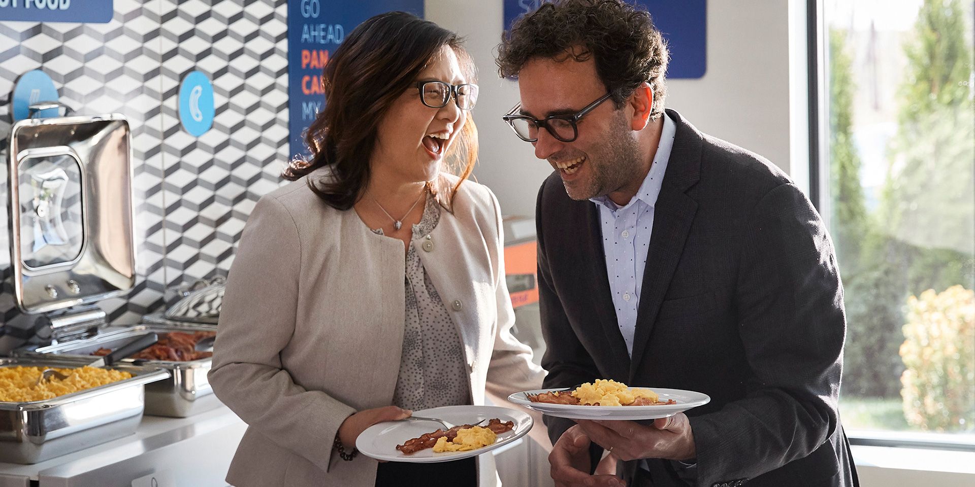 Couple laughing together white eating breakfast