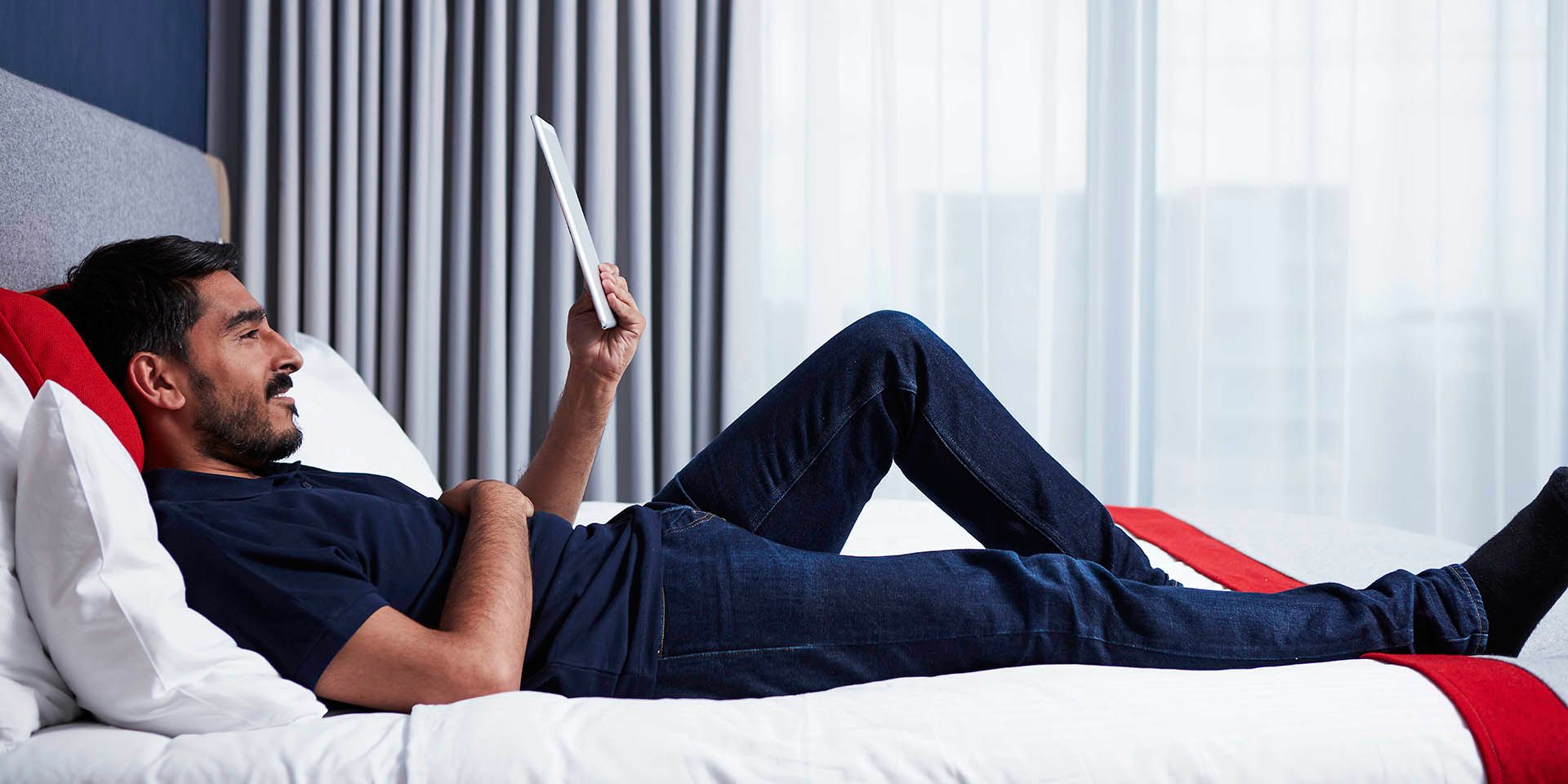 man lying on bed reading