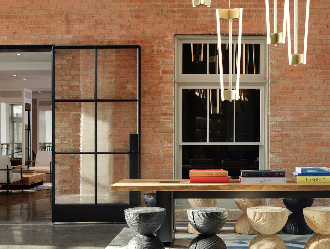 lobby living room with stool seating against an exposed brick wall