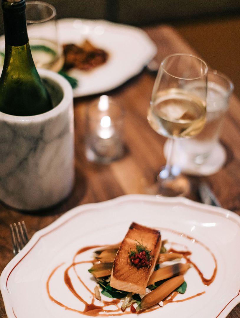 artistic plating of salmon on white tablecloth