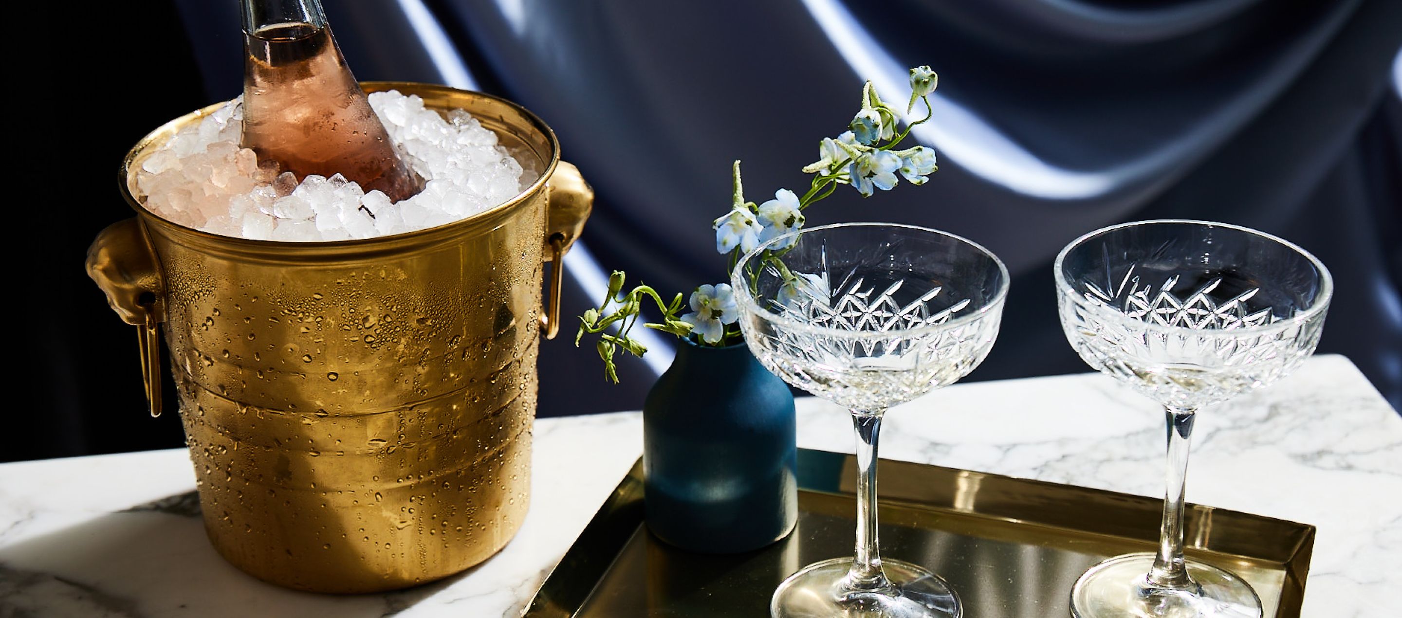 close up of two champagne glasses filled with bubbly and a glass candy jar