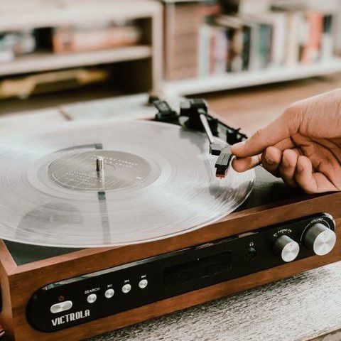 hand laying the needle on a vinyl record player