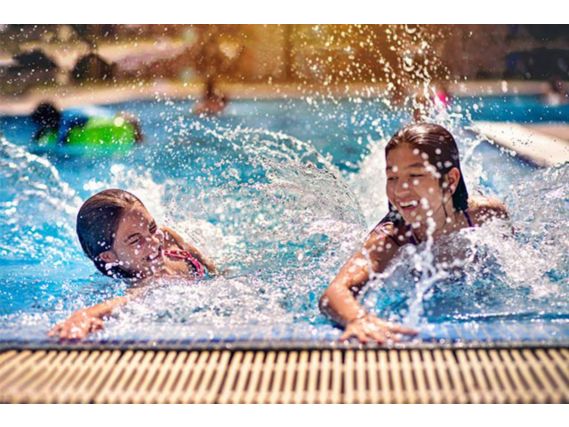 Dos niñas chapotean en una piscina