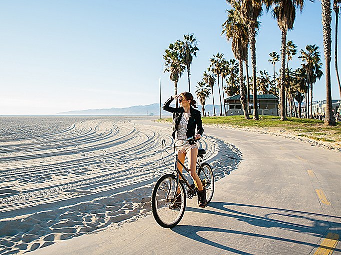 Woman on bike on path at the beach