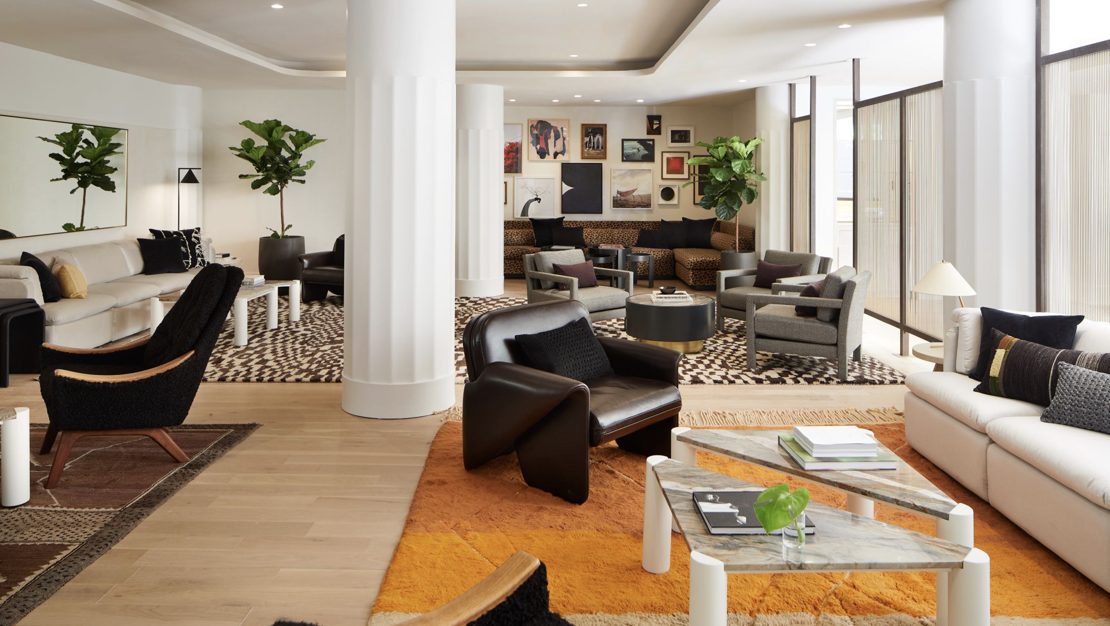 lobby living room with white couches, brown leather seating, white columns