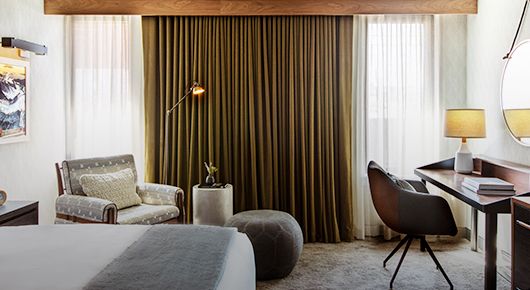 Modern neutral hotel room with full curtained window