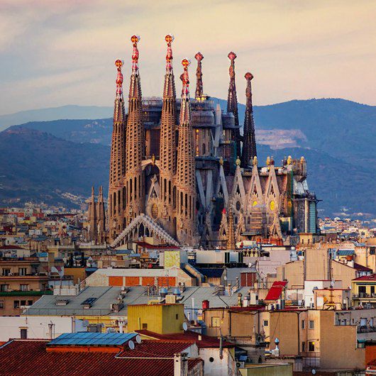 Storici edifici sulle colline dominano lo skyline con catene montuose sullo sfondo
