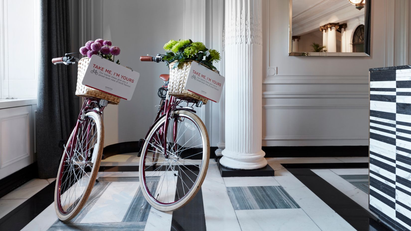 two bicycles with flower baskets in a white and gray marble lobby
