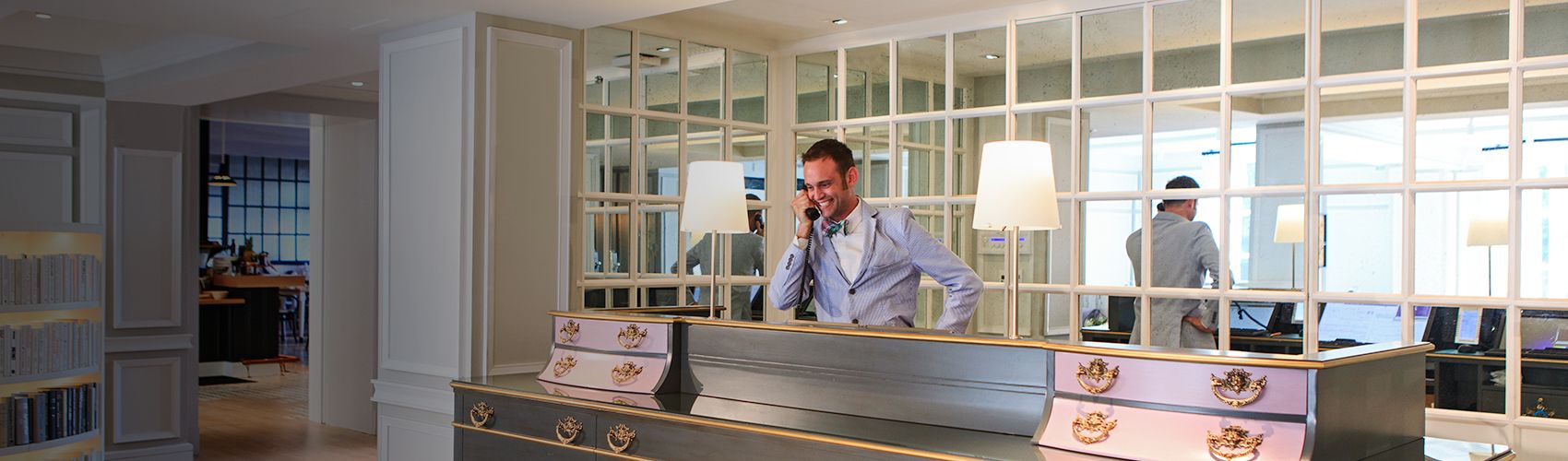 A hotel concierge taking calls at the front desk