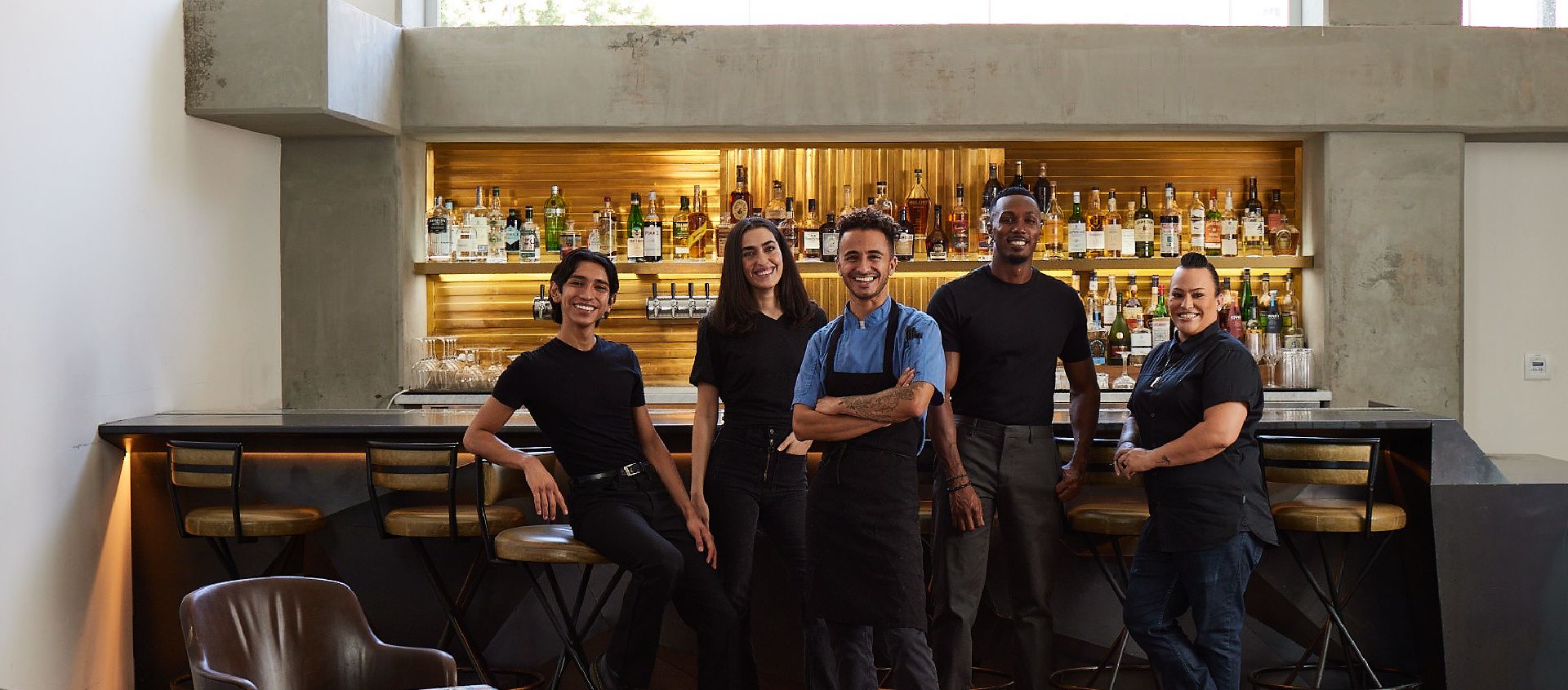 group of employees hanging out in front of bar and windows with mountain views