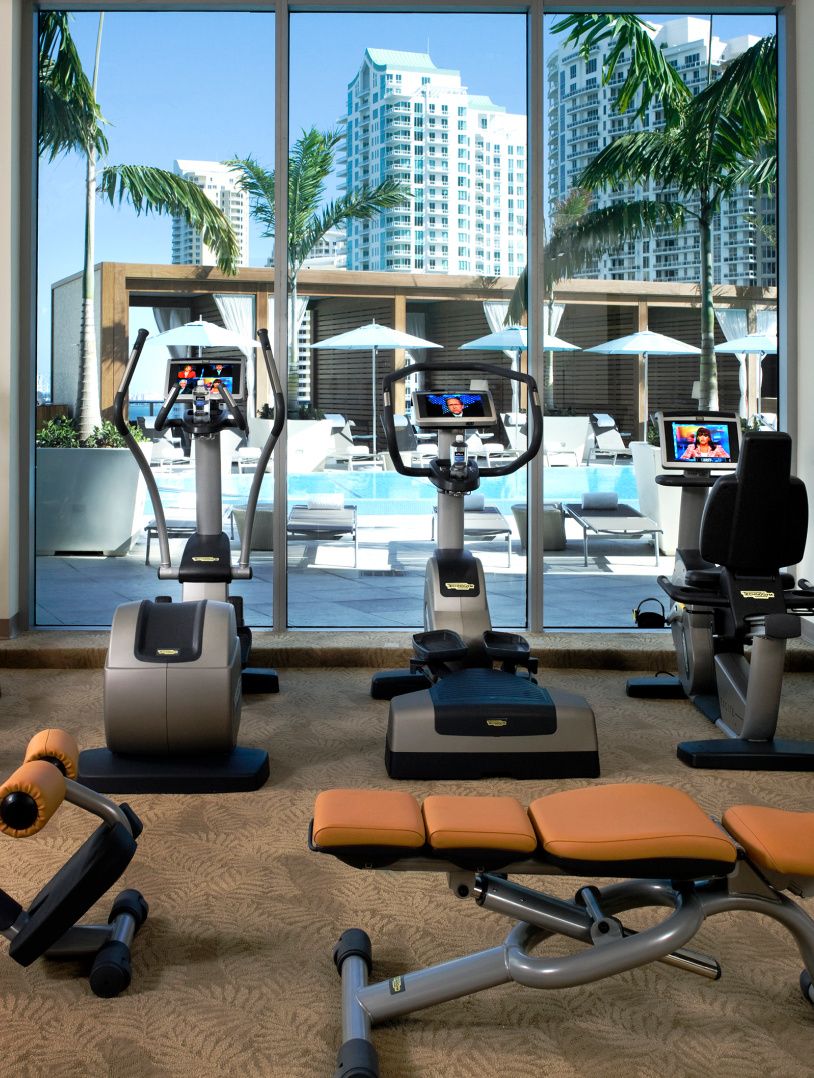fitness equipment in a hotel gym with floor to ceiling windows