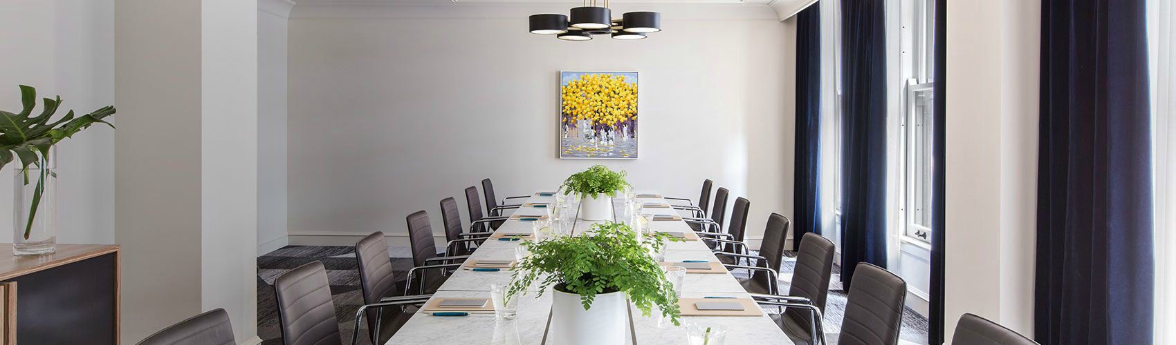 An upscale meeting room with potted plants on the table