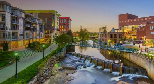 Puente sobre un río flanqueado por edificios en Greenville, Carolina del Sur 