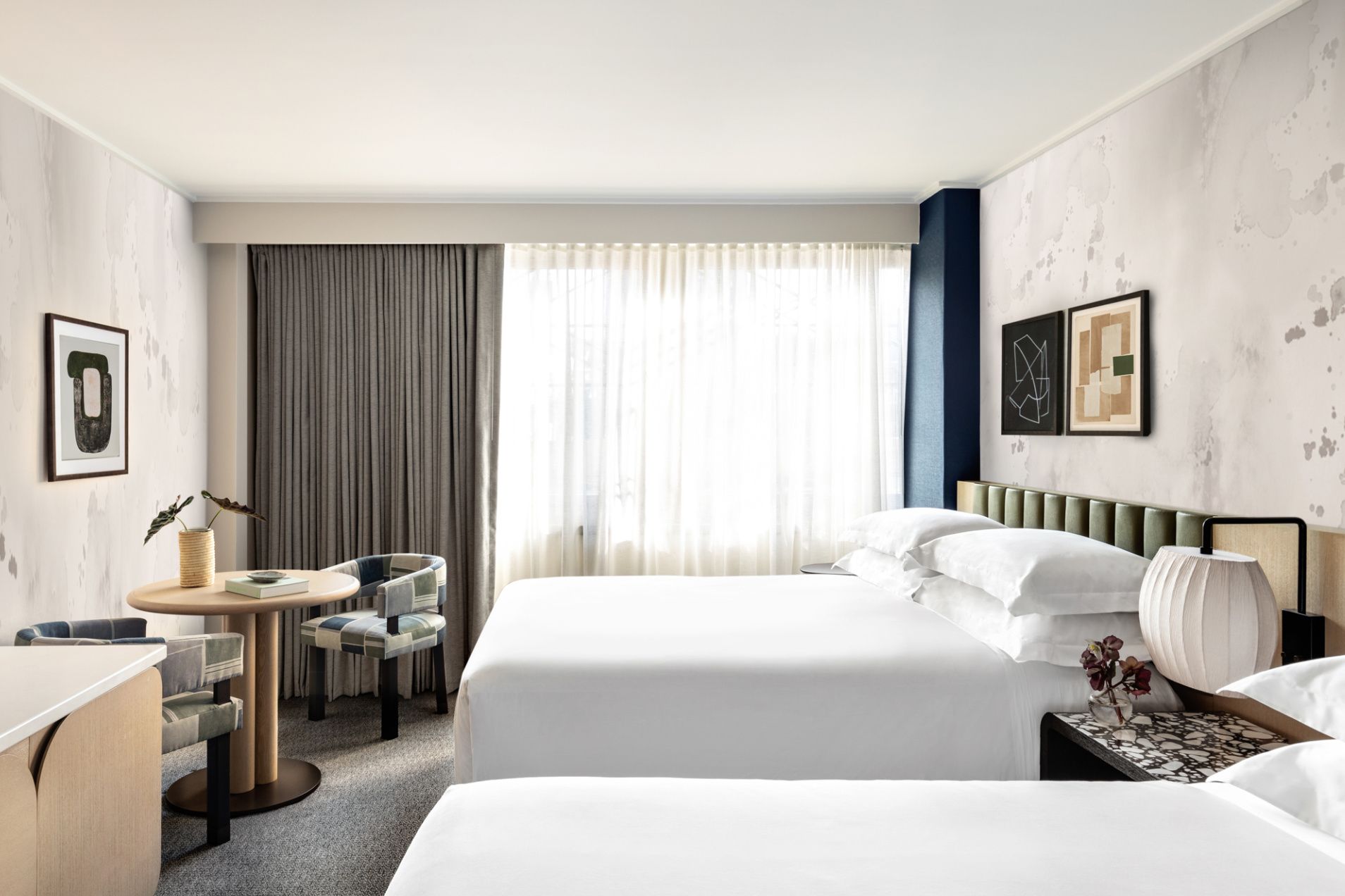 kimpton hotel theta guestroom with large windows and modern art in new york