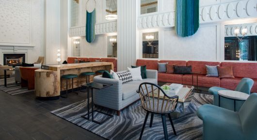 Hotel lobby with coral couches and ombre blue macrame artwork