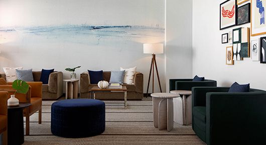 Hotel lobby with blue watercolor wall and coordinating seating 