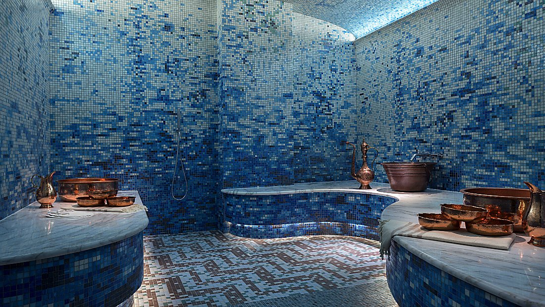 a calming room in blue mosaic tile and copper decor