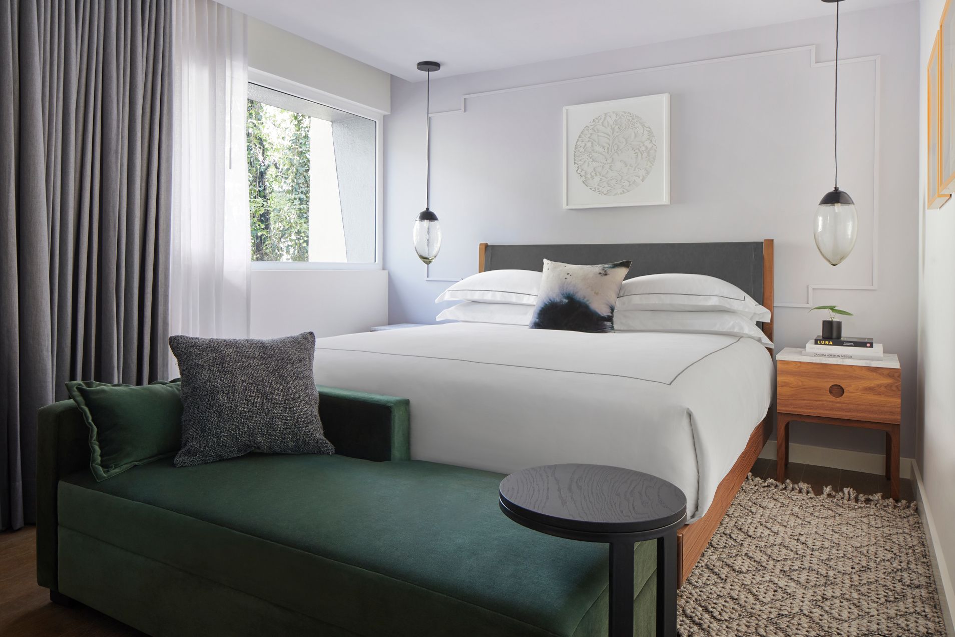 crisp white bed and deep green plush seating in new mexico city hotel