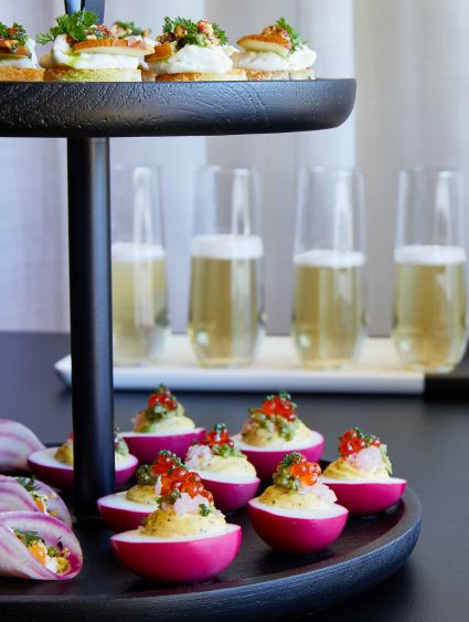 close up of a catering display with deviled eggs and stemless champagne glassware
