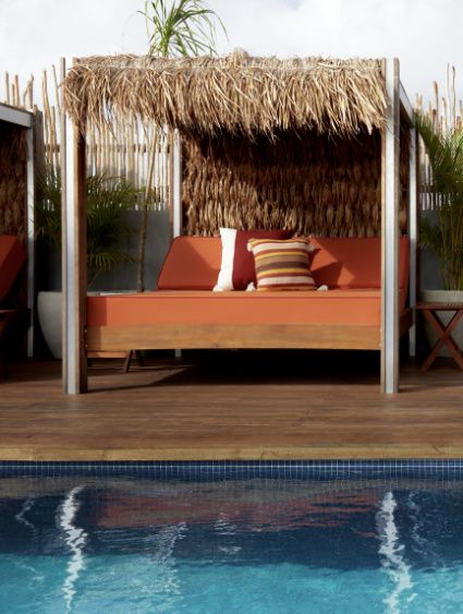 cabanas with thatched roofs on a rooftop pool deck