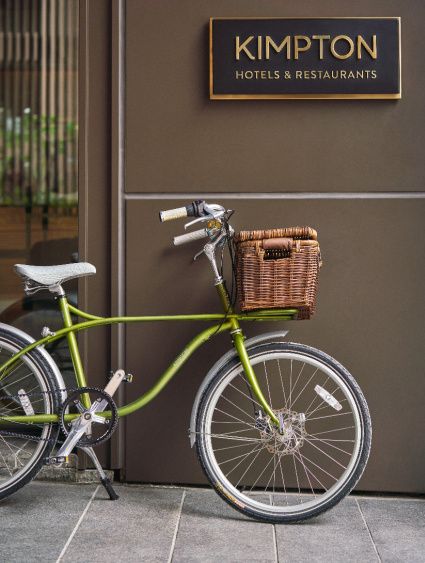 a bright green bike against the outside wall of a boutique hotel